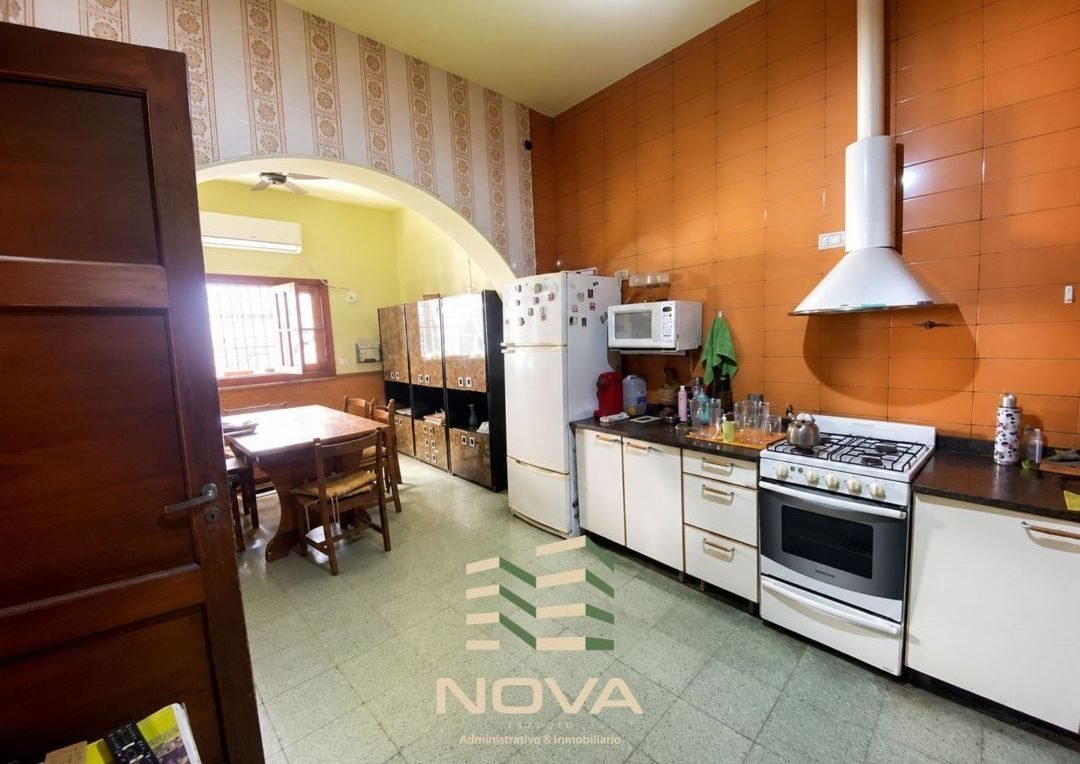 Cocina comedor con cocina a gas, campana y mesada
