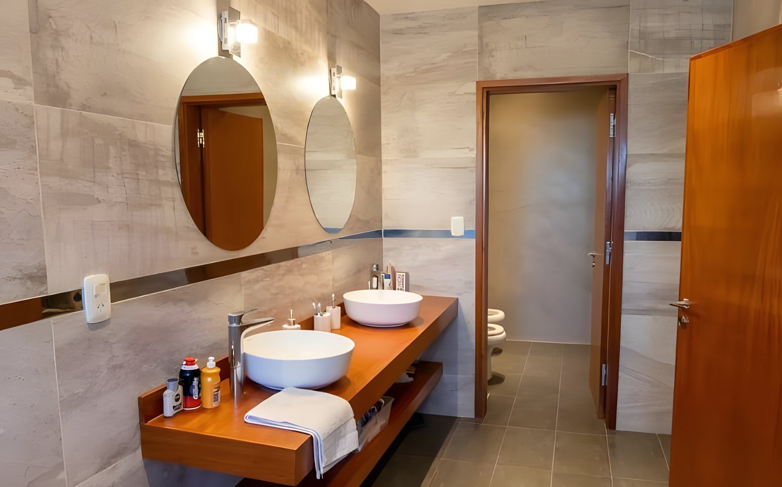 Baño en suite con mesada de madera y doble bacha
