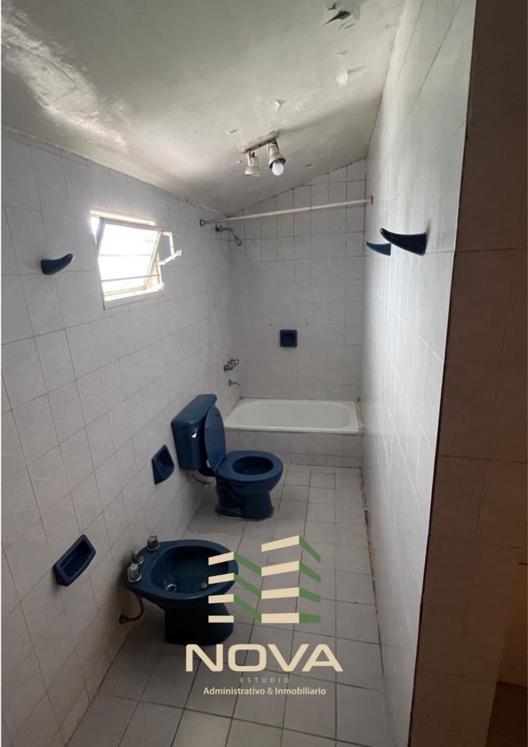Baño con bañera y revestimiento cerámico blanco
