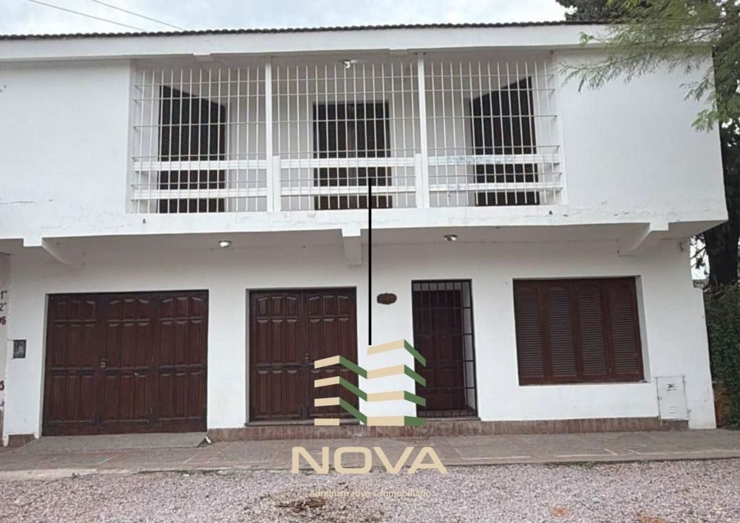 Frente de la casa de 2 plantas sobre calle Libertad, con portones de cochera