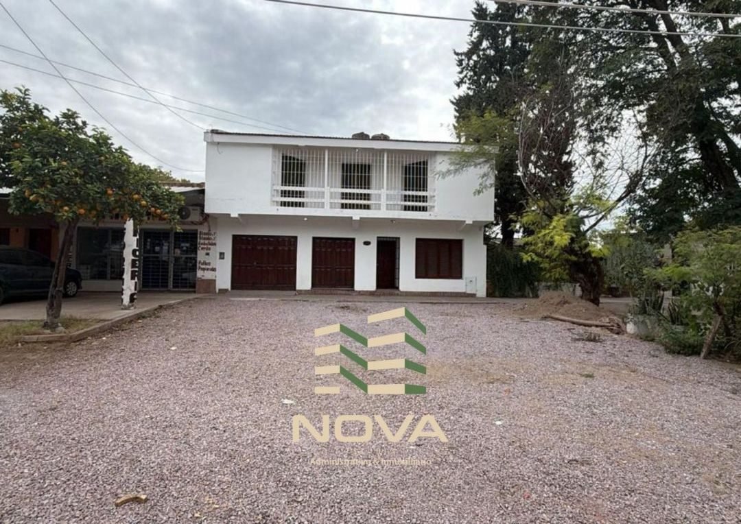 La casa vista desde la calle, con árboles en la vereda