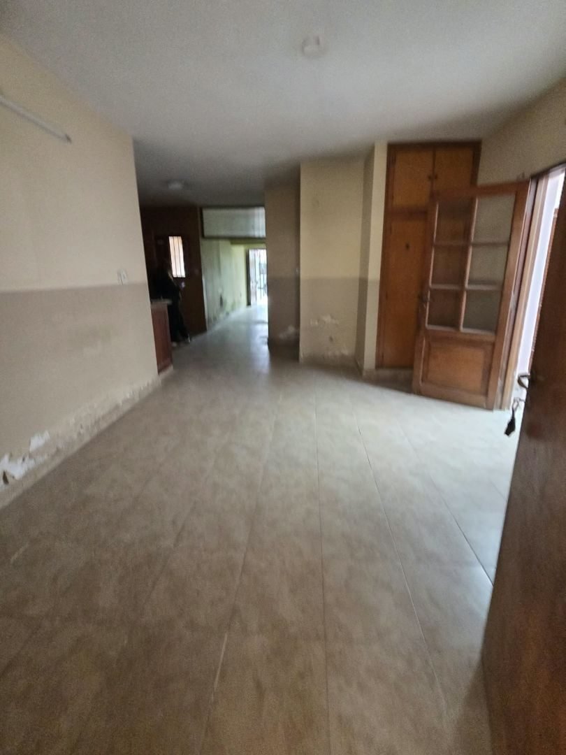 Ambiente amplio con piso cerámico y puertas de madera