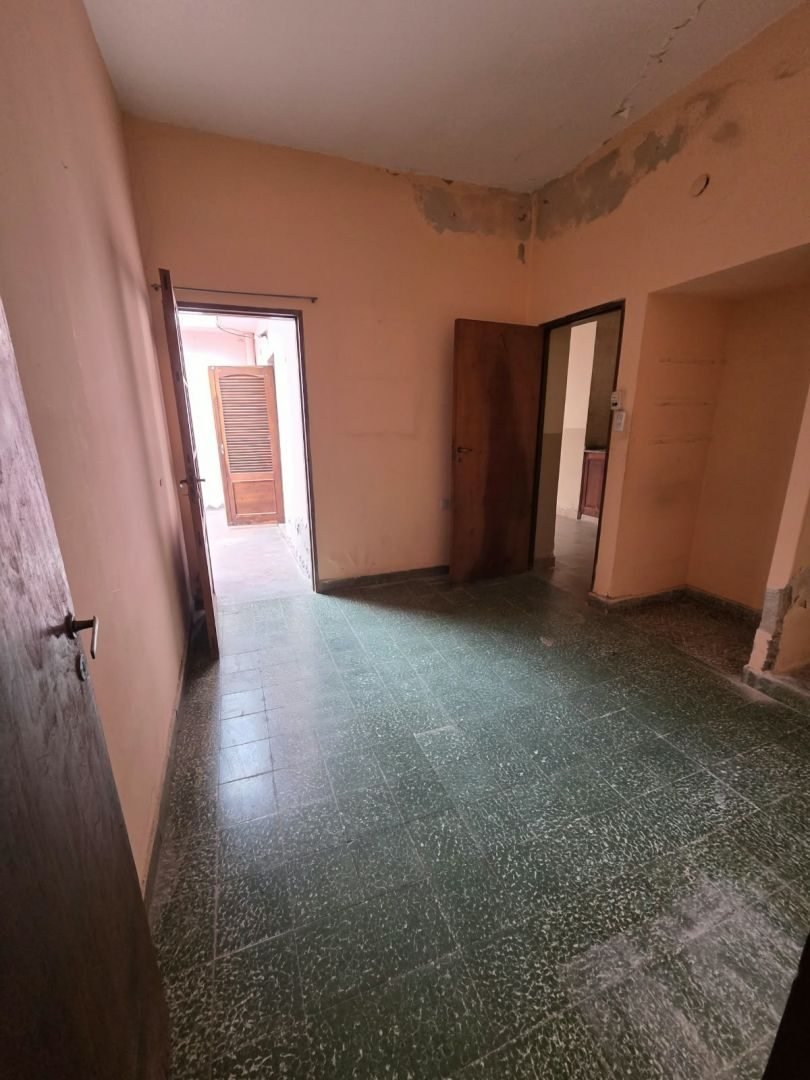 Dormitorio con piso de mosaico y puerta al pasillo