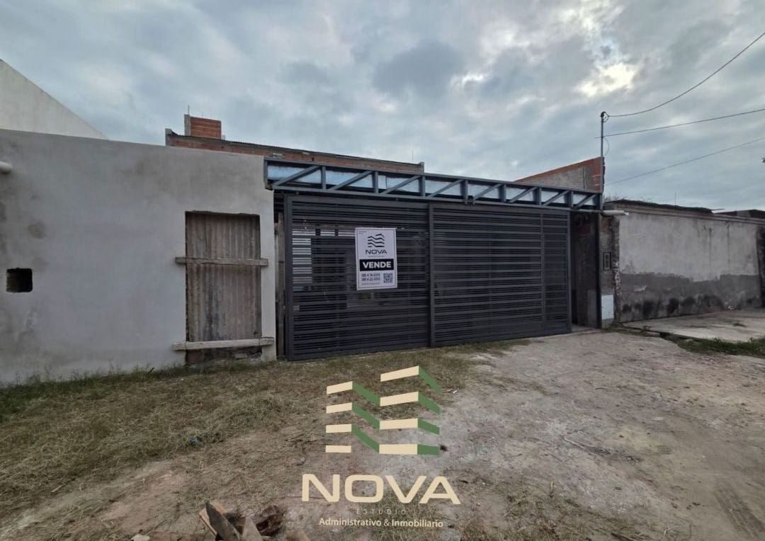 Frente de la casa sobre calle San Lorenzo, con portón de rejas y cartel de NOVA
