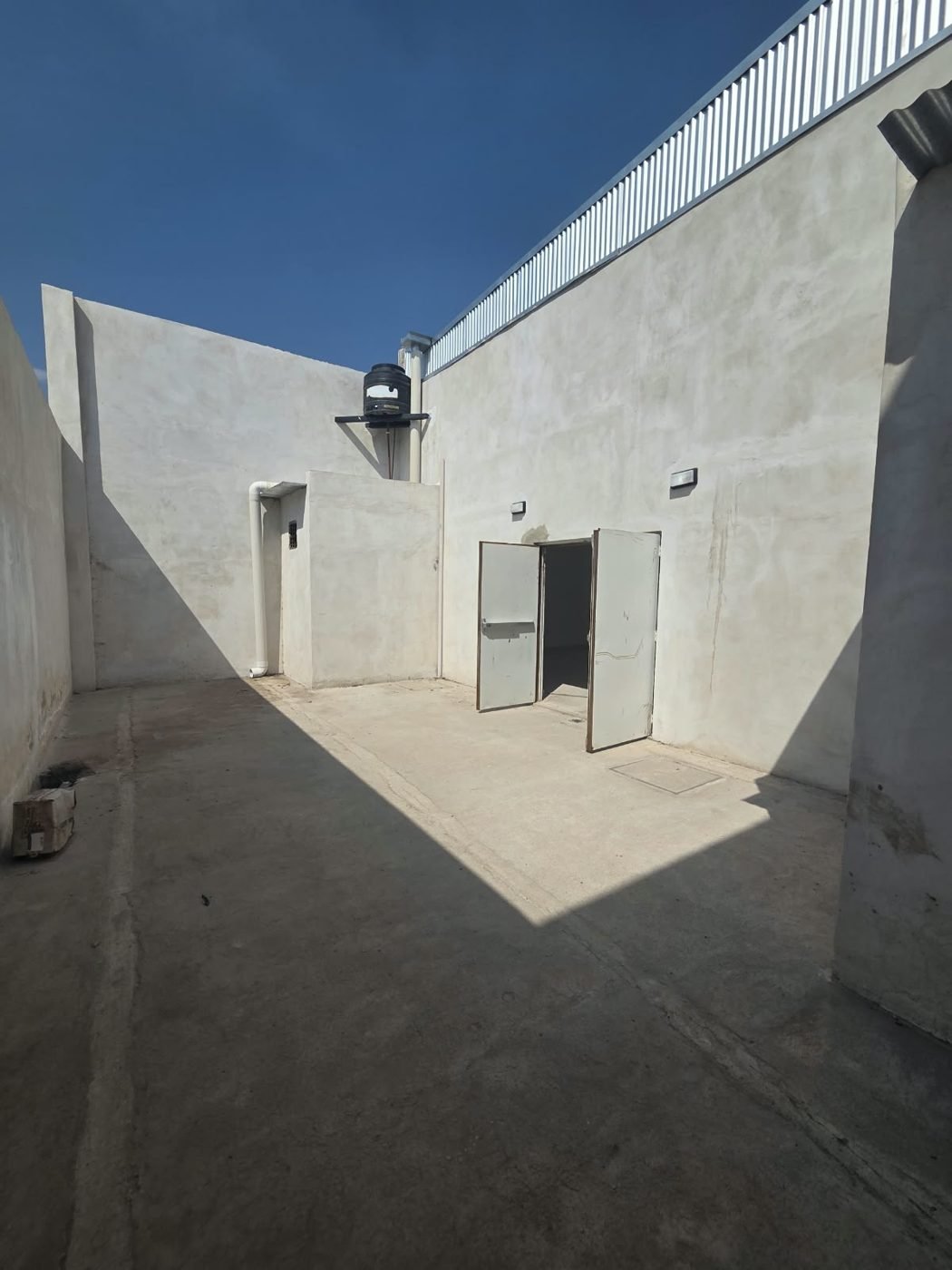 Fondo del patio con tanque de agua y depósito