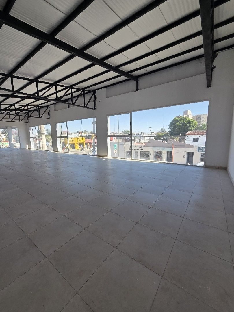 Otro sector del salón, con ventanales y vista al barrio