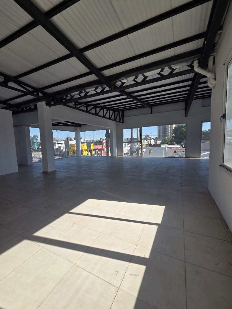 Salón del local en planta alta, amplio y con ventanales hacia la avenida