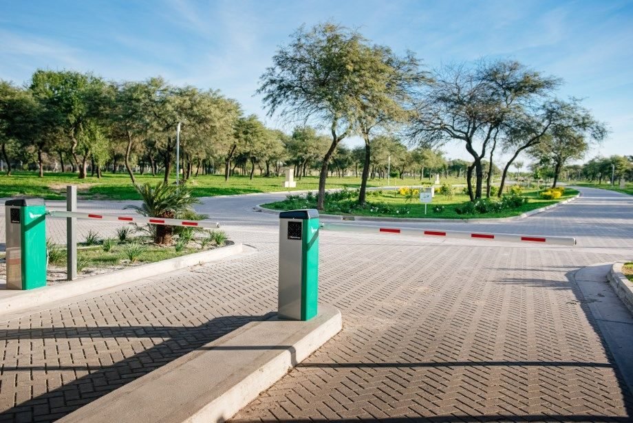 Barreras de ingreso y calles internas con árboles